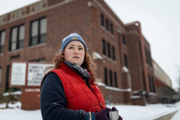 A woman stands outside a school
