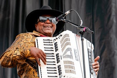 Nathan and the Zydeco Cha Chas performing on an outdoor stage.