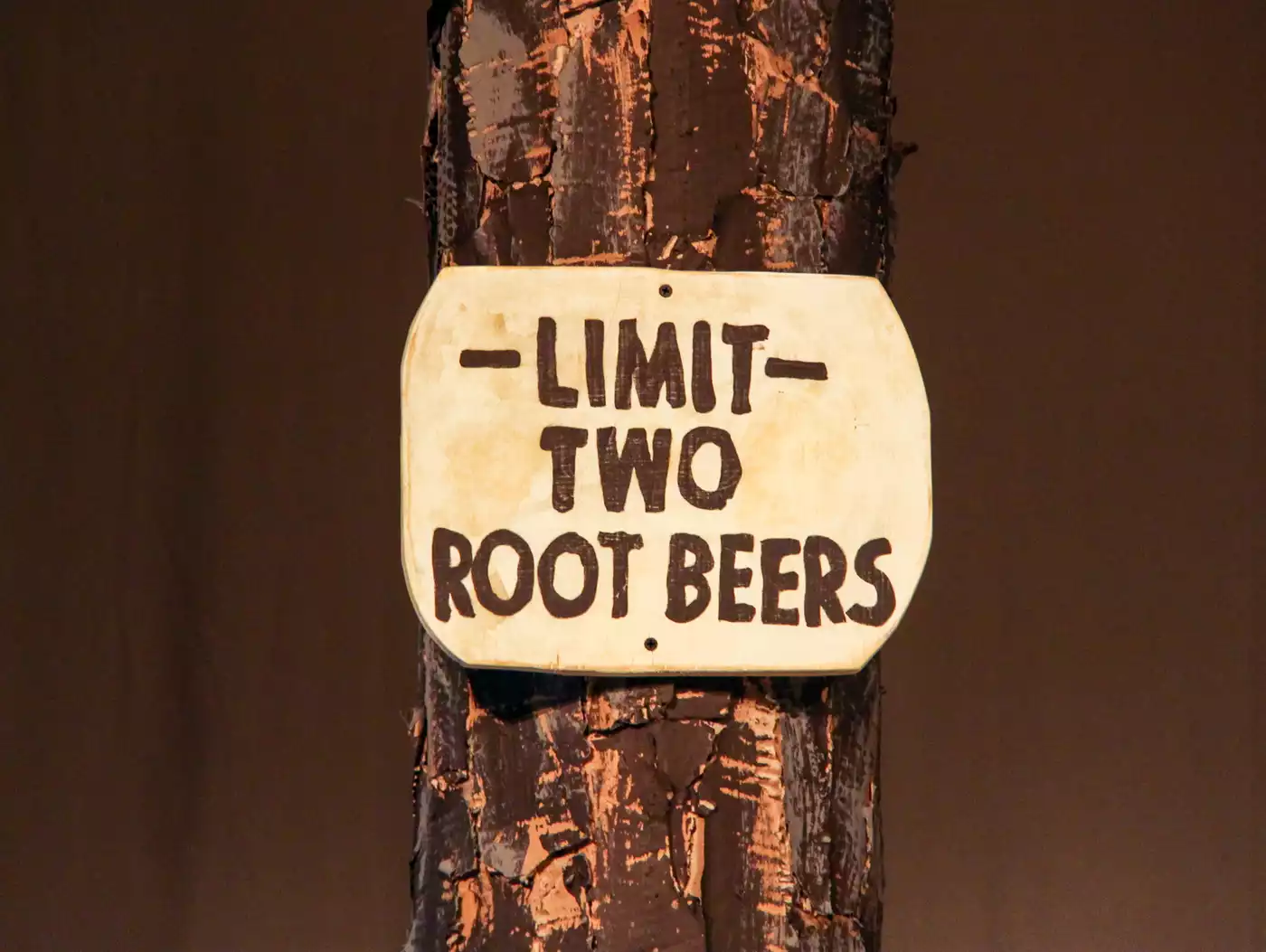 A sign tacked on a tree reads