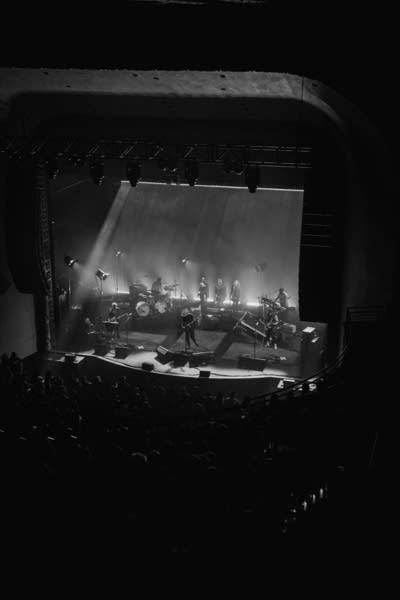 A band performing onstage in a large music venue