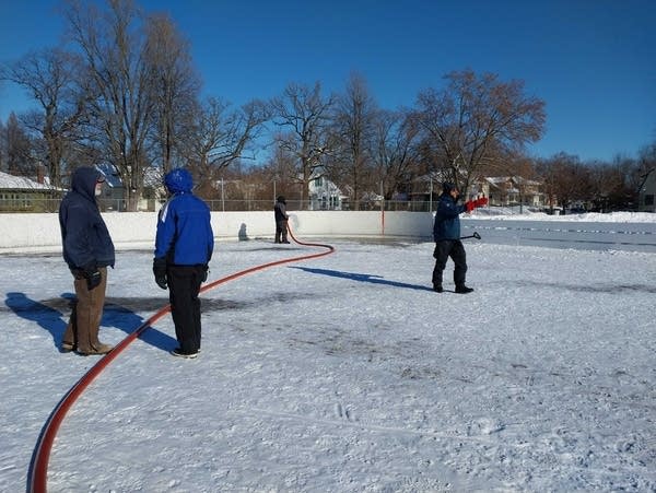 Volunteers build a hockey rink in winter