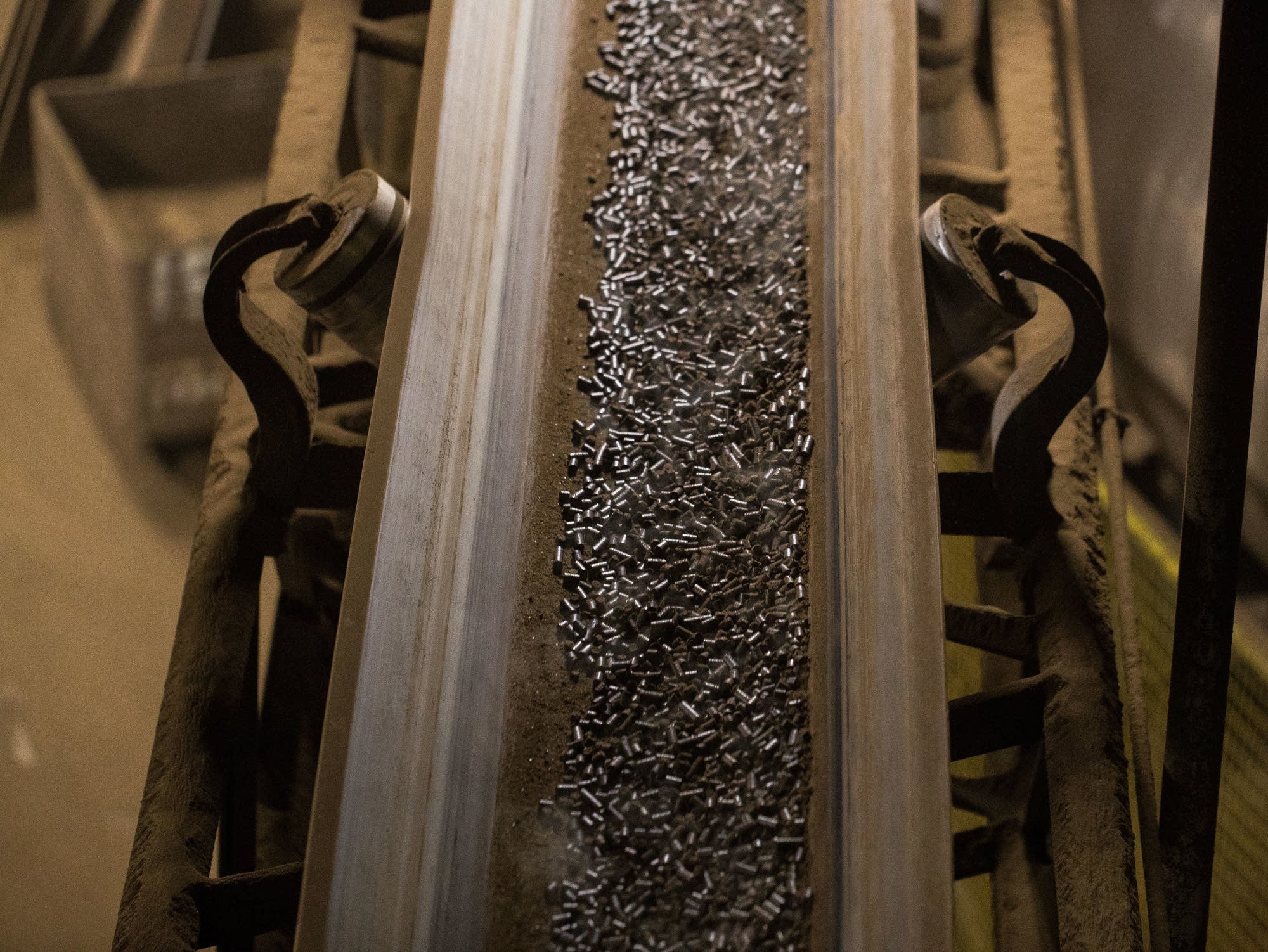Steaming peat that has been pelletized rides along a conveyor belt
