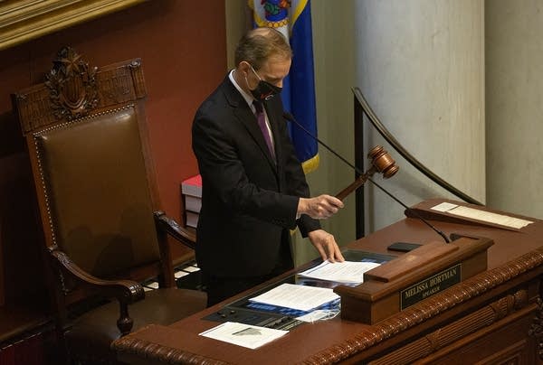 A man hits a gavel on a desk.