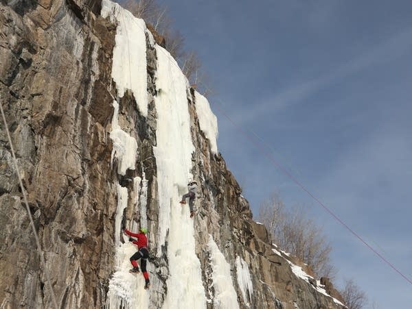 A person scales an icy wall