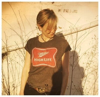 A woman standing outdoors in the sunshine