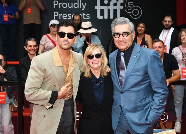 Three people pose for a photo on arrival at a film festival screening
