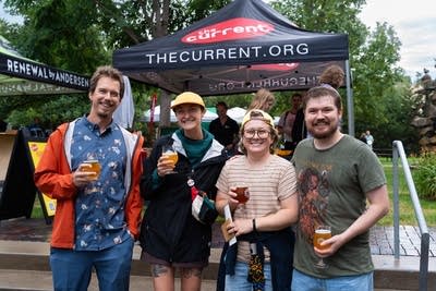 4 people posing for a photo with drinks in their hand