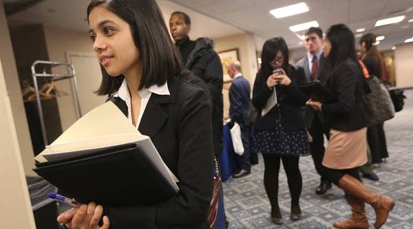 Dipti Sharma (L) waits with other applicants to meet potential employers at a Manhattan job fair on January 17, 2013 in New York City.