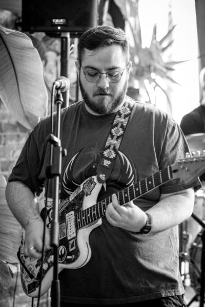 A musician plays guitar in a small music venue