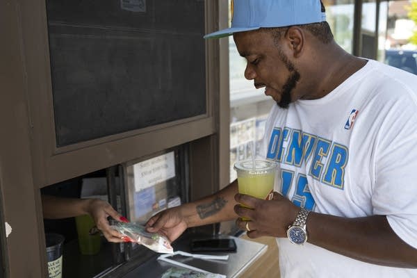 A man buys a drink and ice cream.