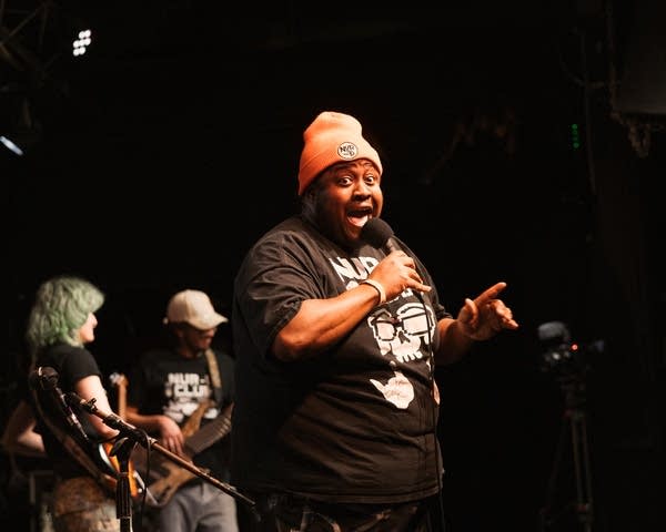 A hip-hop artist performs onstage in a music venue