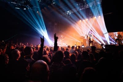 A band performs onstage in a crowded music venue