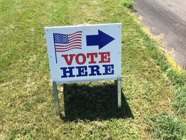 A sign directs voters to the entrance at Susan B. Anthony Middle School in Minneapolis during Minnesota's primary election on Tuesday, Aug. 11, 2020.