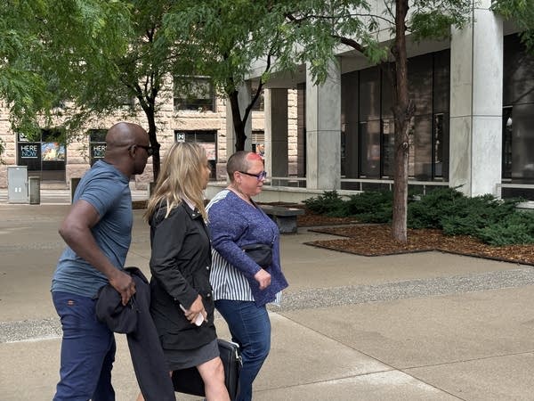 Three people walk toward a courthouse