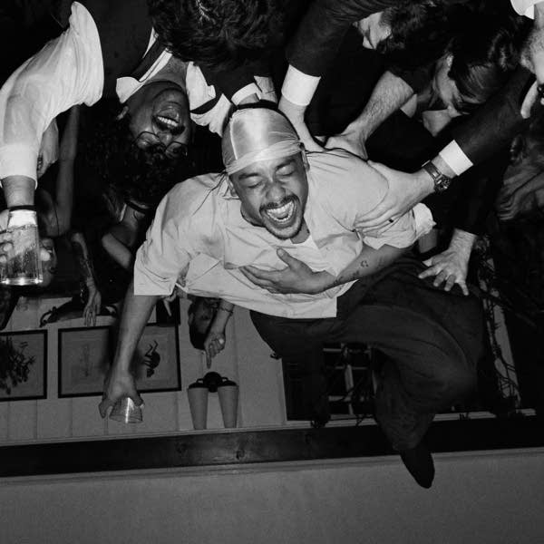 An upside-down image of a musician smiling while crowd surfing
