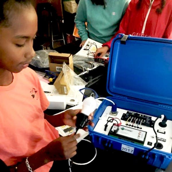 A student works on assembling a solar suitcase.