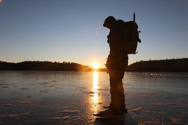 Sven Hoaglund inspects the ice at sunrise in the Boundary Water.