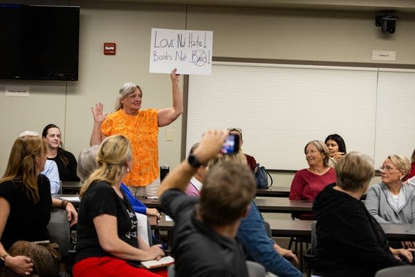 A person holds a sign that says love not hate, books not bans