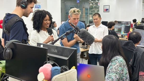 ADP Chief Economist Nela Richardson (second from left) and “Marketplace” host Kai Ryssdal (center) speak with an employee at Saigon Technology.