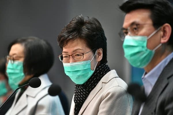 Hong Kong's Chief Executive Carrie Lam (C) takes part in a press conference while wearing a facemask in Hong Kong on January 28, 2020, to update the territory on the situation concerning the SARS-like virus that has infected at least eight in the city and killed at least 106 people in mainland China. - Eight people are known to have the disease in Hong Kong, which of those, six arrived via a newly built high-speed train terminal that connects the city to the mainland. (Photo by Anthony WALLACE / AFP) (Photo by ANTHONY WALLACE/AFP via Getty Images)