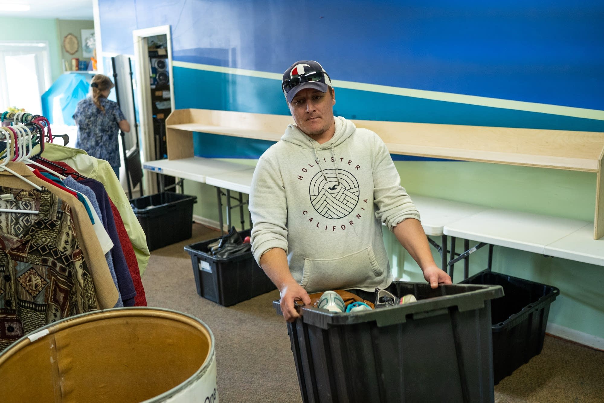 Johnny Petty carries a box of donated shoes into the basement