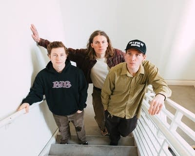 Three guys stand in a stairwell together for a portrait