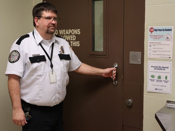 A man in uniform opens a door