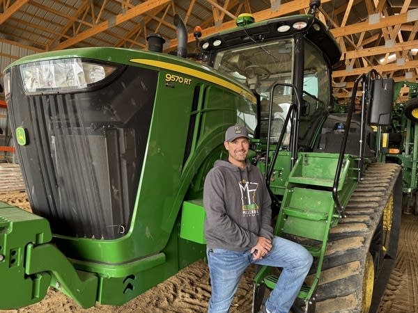 A man standing on stairs of a tractor