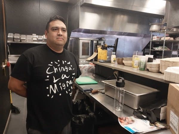 Man poses for photo in restaurant kitchen