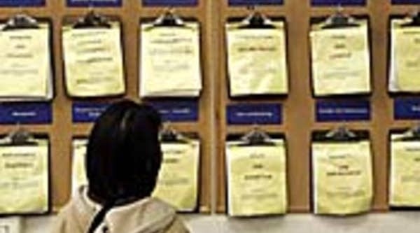 A job seeker looks at a job listing board in Oakland, Calif.