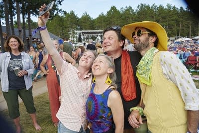 Four people take a selfie at a music festival 
