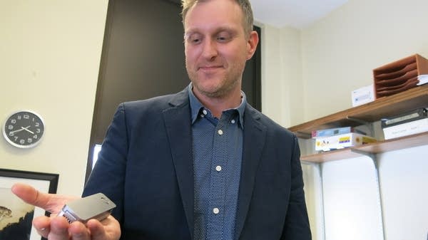 Research professor Peter Larsen holds a DNA sequencer