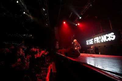 A rapper performs onstage during a show in a music venue
