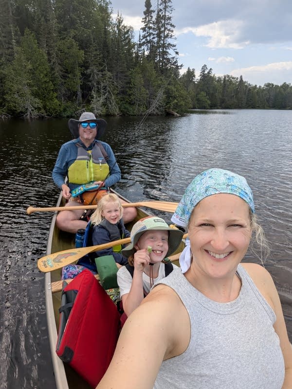 A family sits in a canoe on the water 