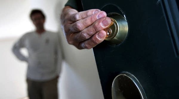 An eviction team changes the lock on a front door during a home foreclosure on September 21, 2011 in Longmont, Colo.