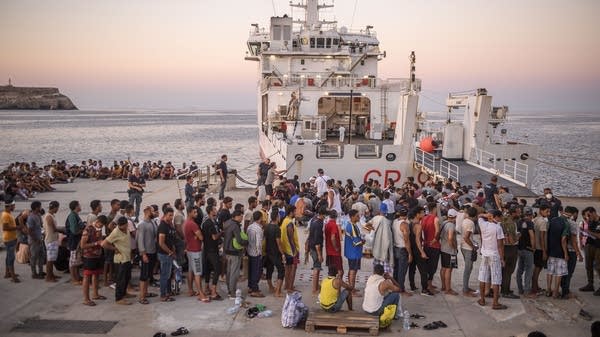 Migrants wait to board the Coast Guard ship