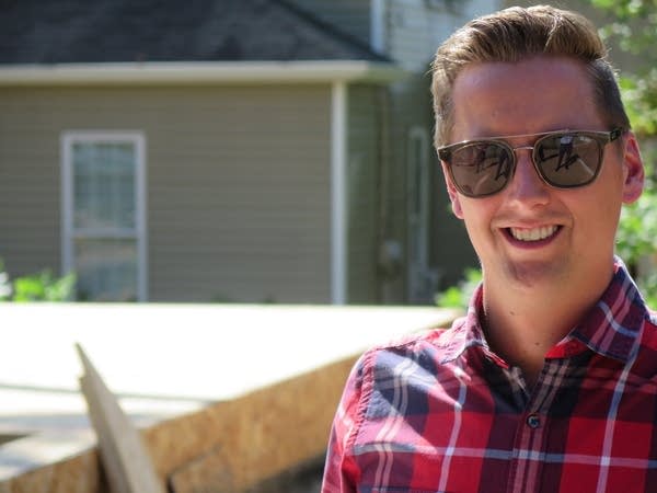 A man with sunglasses stands near a construction project