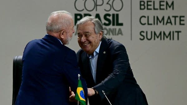 Brazil's President Luiz Inacio Lula da Silva (L) is greeted by UN Secretary General Antonio Guterres at COP30.