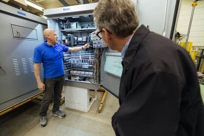 A man showing the inside of traffic signal cabinet