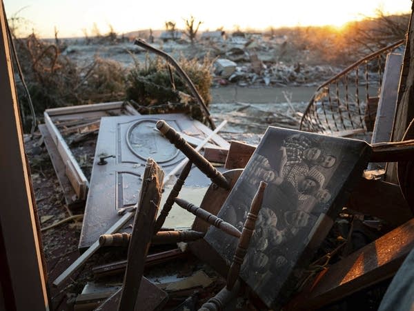 A family portrait is seen among the debris inside of a house