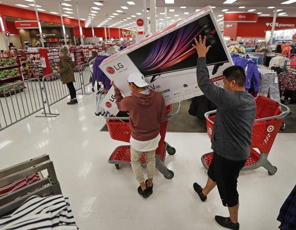 Shoppers put a TV in a cart.