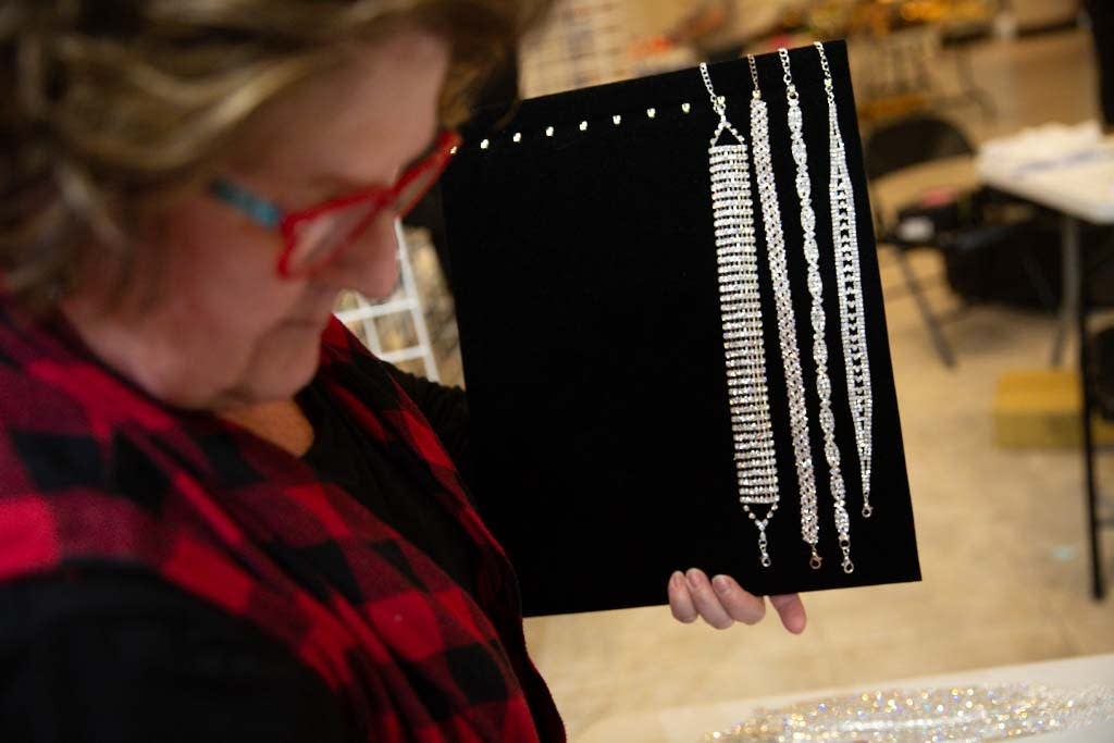 Volunteer Karen Tiedens of Lake Elmo organizes jeweled chokers.