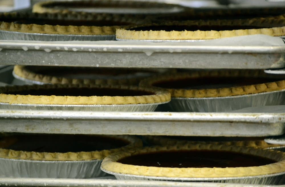 Pumpkin pies cool on a rack.