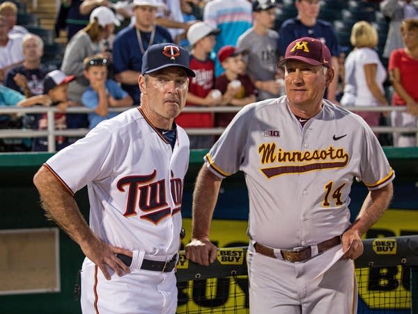 Two men in baseball uniforms talk with each other