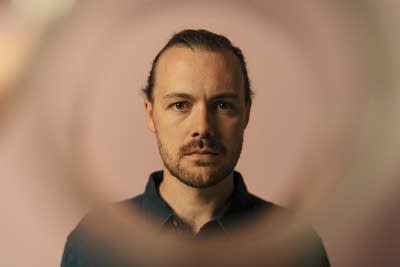 Portrait of a man looking into the neck of a bottle