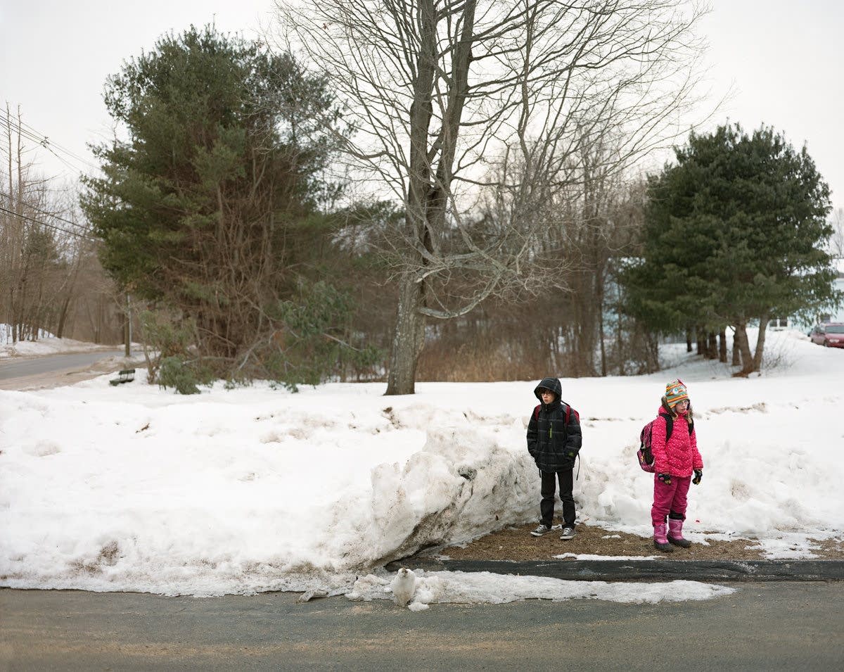 Children wait for their morning bus to school.