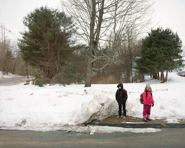 Children wait for their morning bus to school. 