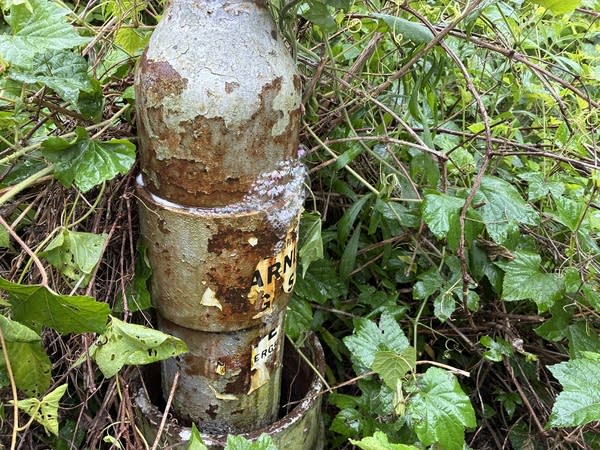 Dousing a leaking oil well in soapy water reveals the leak, as escaping gases create bubbles around a metal rim.
