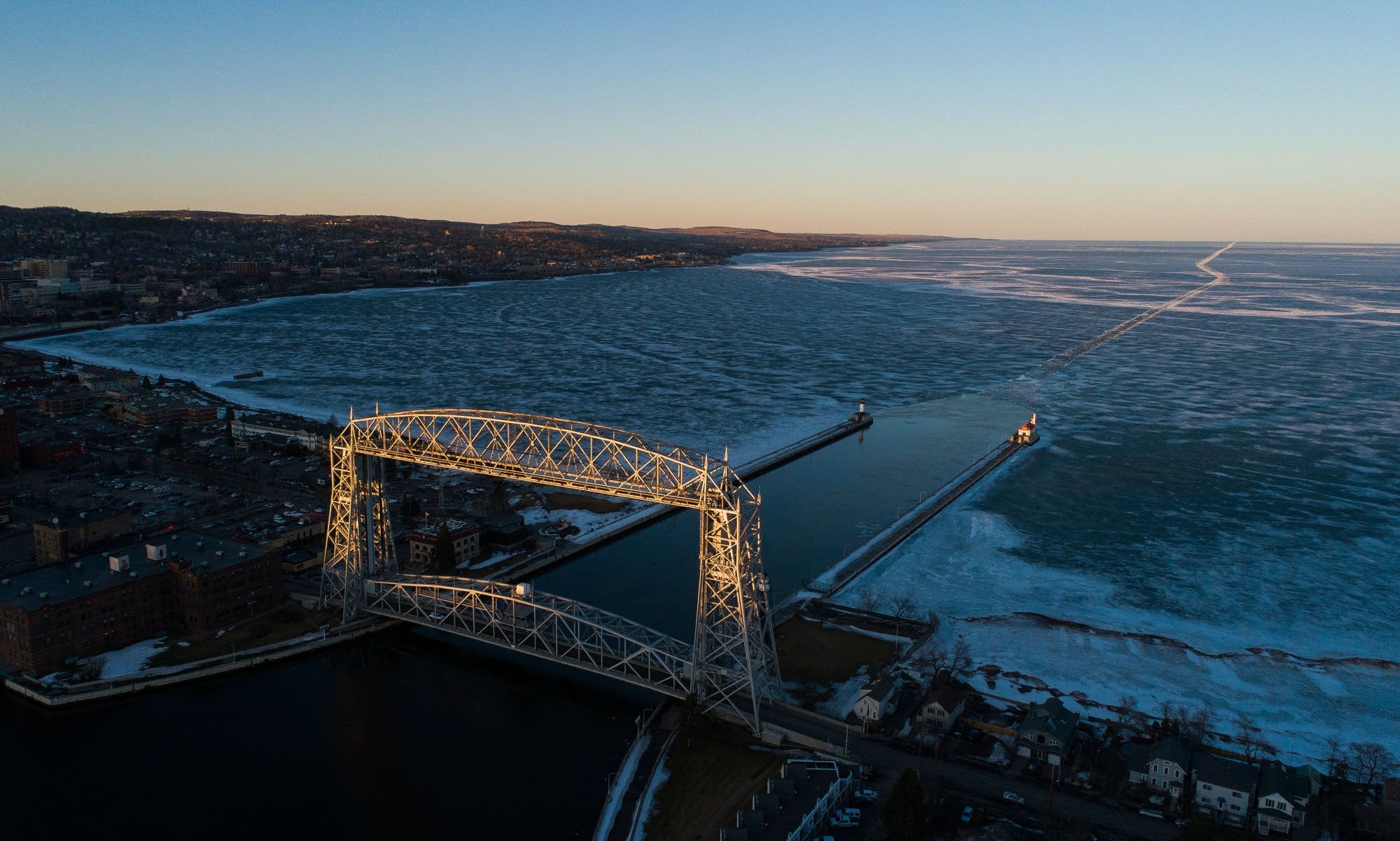 The sun sets on Duluths aerial lift bridge and the route left in the ice