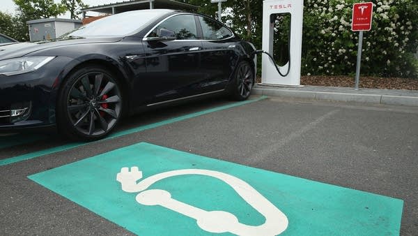 A Tesla sedan stands at a charging station at a highway rest stop near Rieden, Germany, in 2015. 
